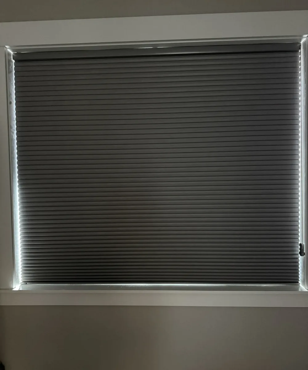 Blackout cellular shade fully lowered, with daylight showing only as a thin line around its edges
