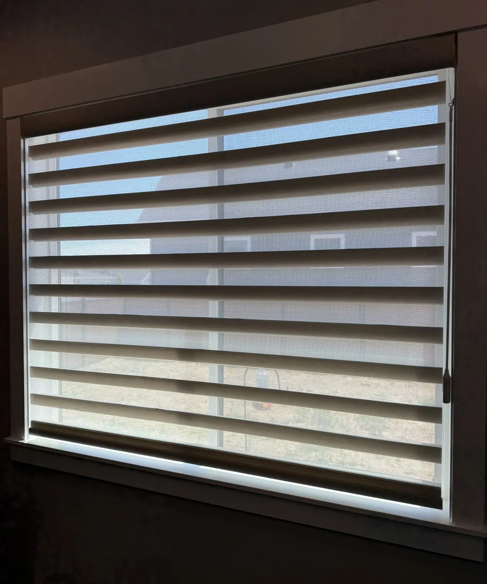 Zebra shade with its sheer and solid bands aligned, daylight coming through the sheers